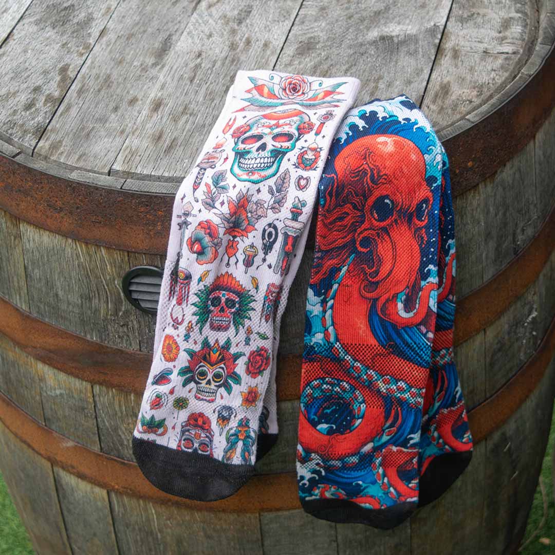 Pair of American Traditional and Kraken Vitals socks displayed on a barrel